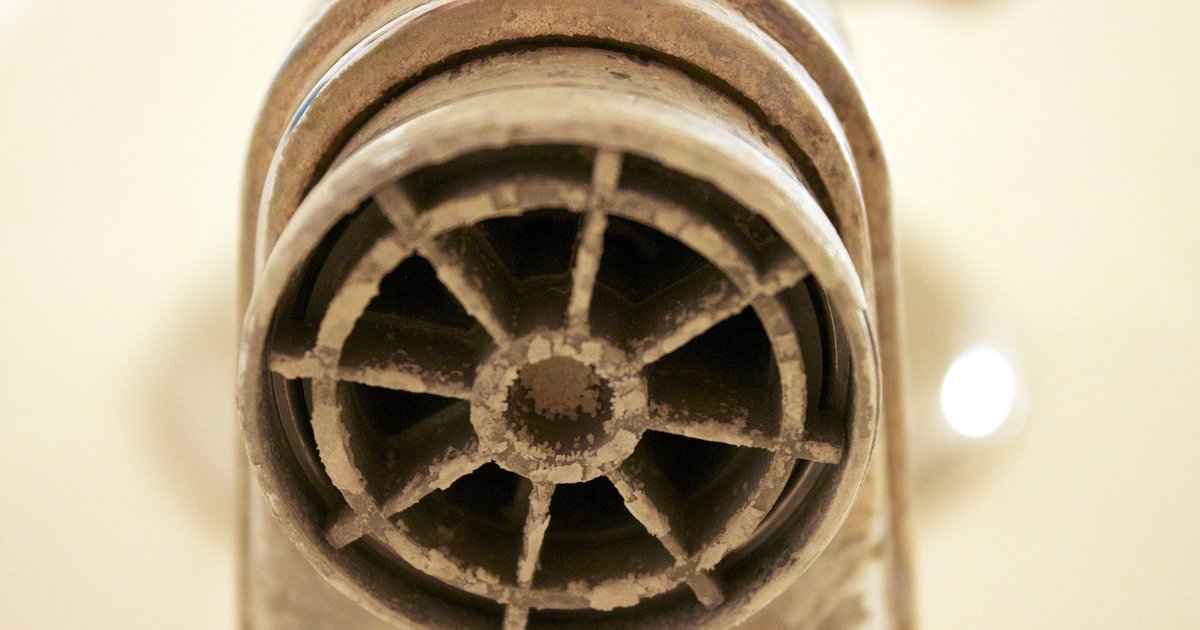 A homeowner inspecting a kitchen faucet for water odor in an Orlando-area home